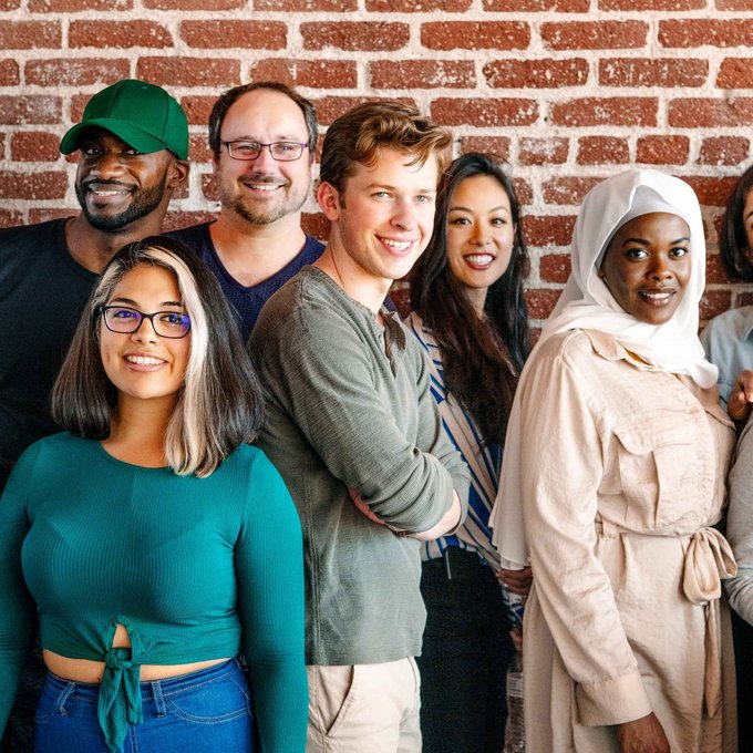 Gruppe von diversen Menschen, die fröhlich in die Kamera blicken 