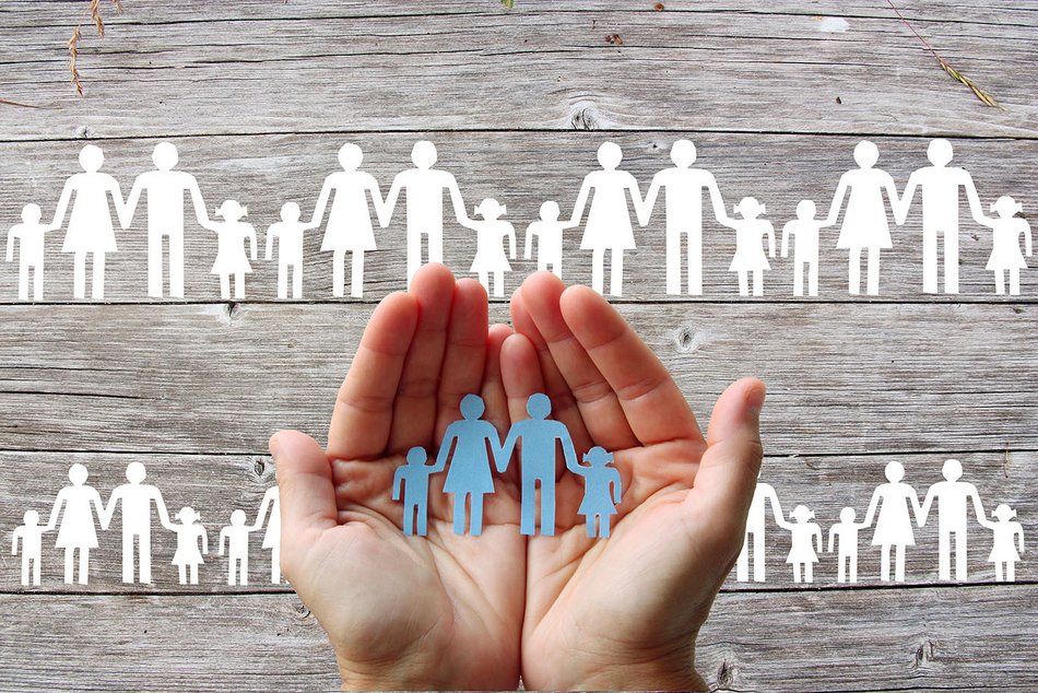 Hände halten eine Familie aus Papier