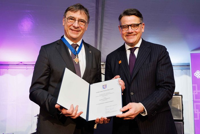 Volker Jung hält zusammen mit Ministerpräsident Boris Rhein die Urkunde für den Hessischen Verdienstorden