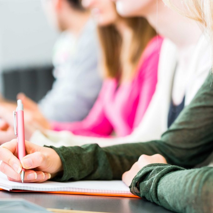 Hände mehrerer Personen mit Stift und Papier