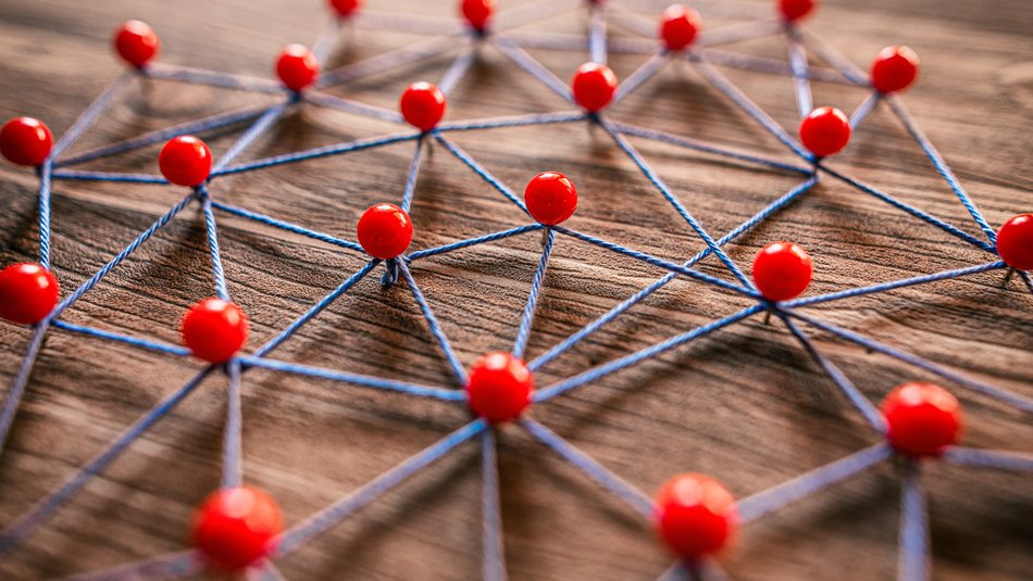 Stecknadeln halten ein Netz aus Fäden zusammen