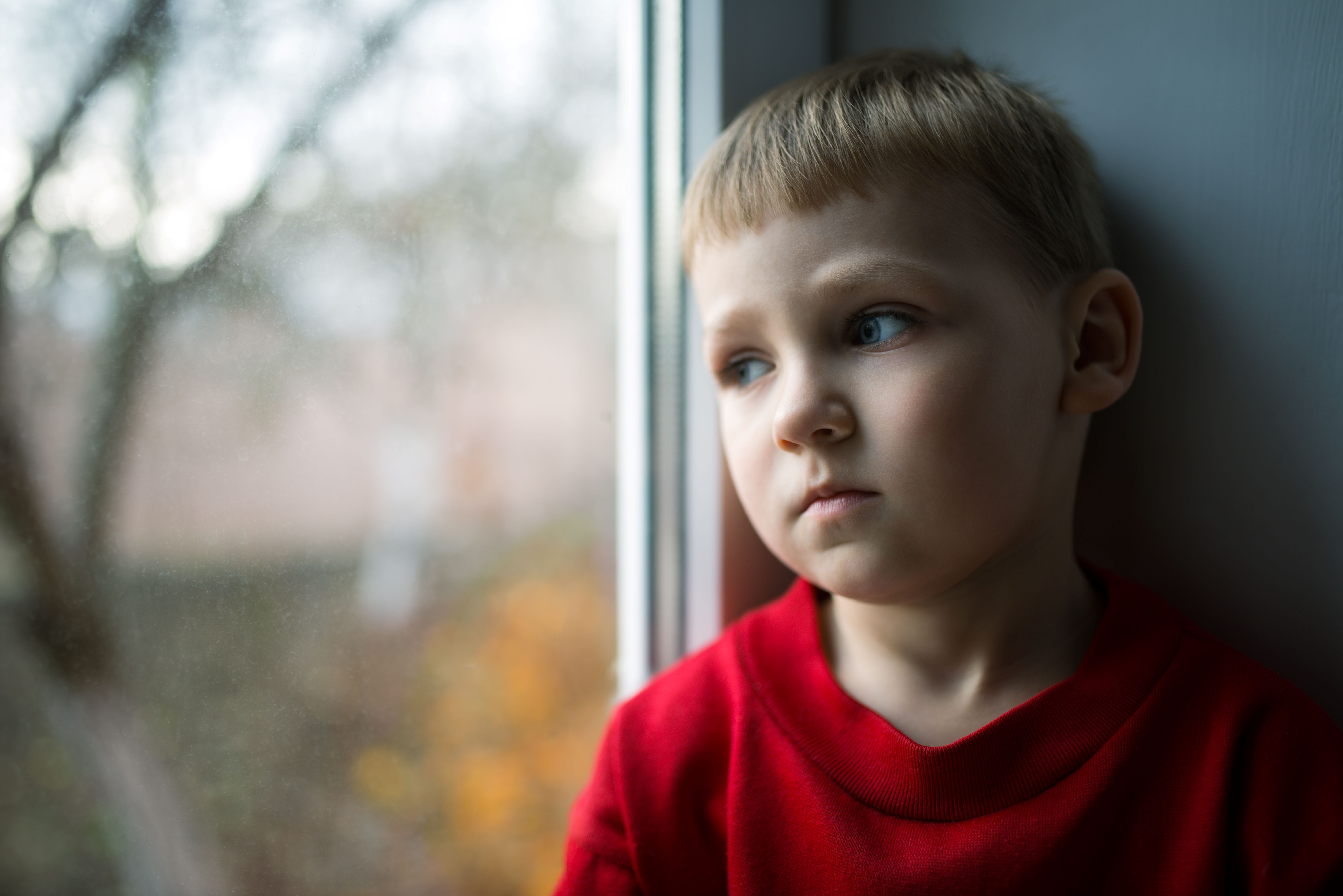 Traurig schauendes Kind im Grundschulalter