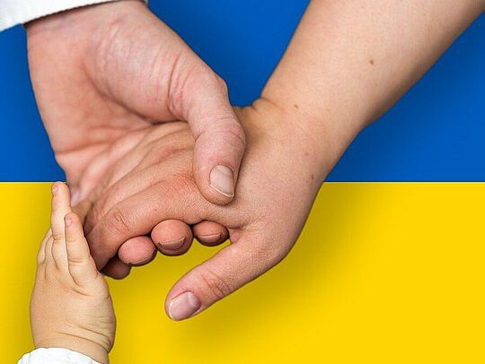 Haltende Hände auf ukrainischer Flagge