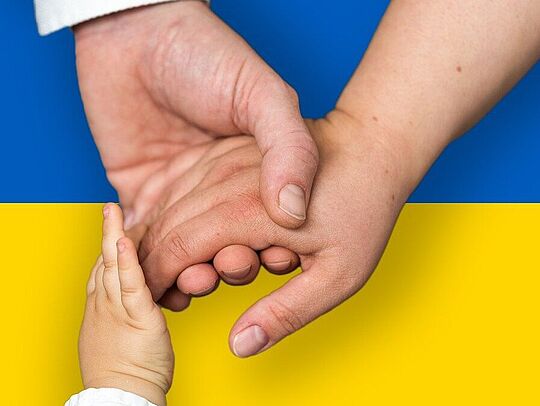 Haltende Hände auf ukrainischer Flagge